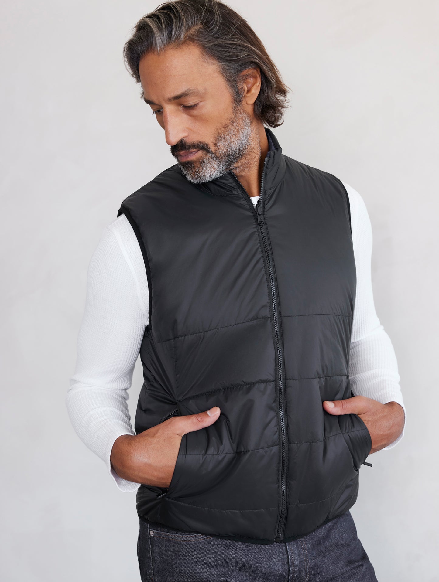 man wearing black side of reversible insulated vest