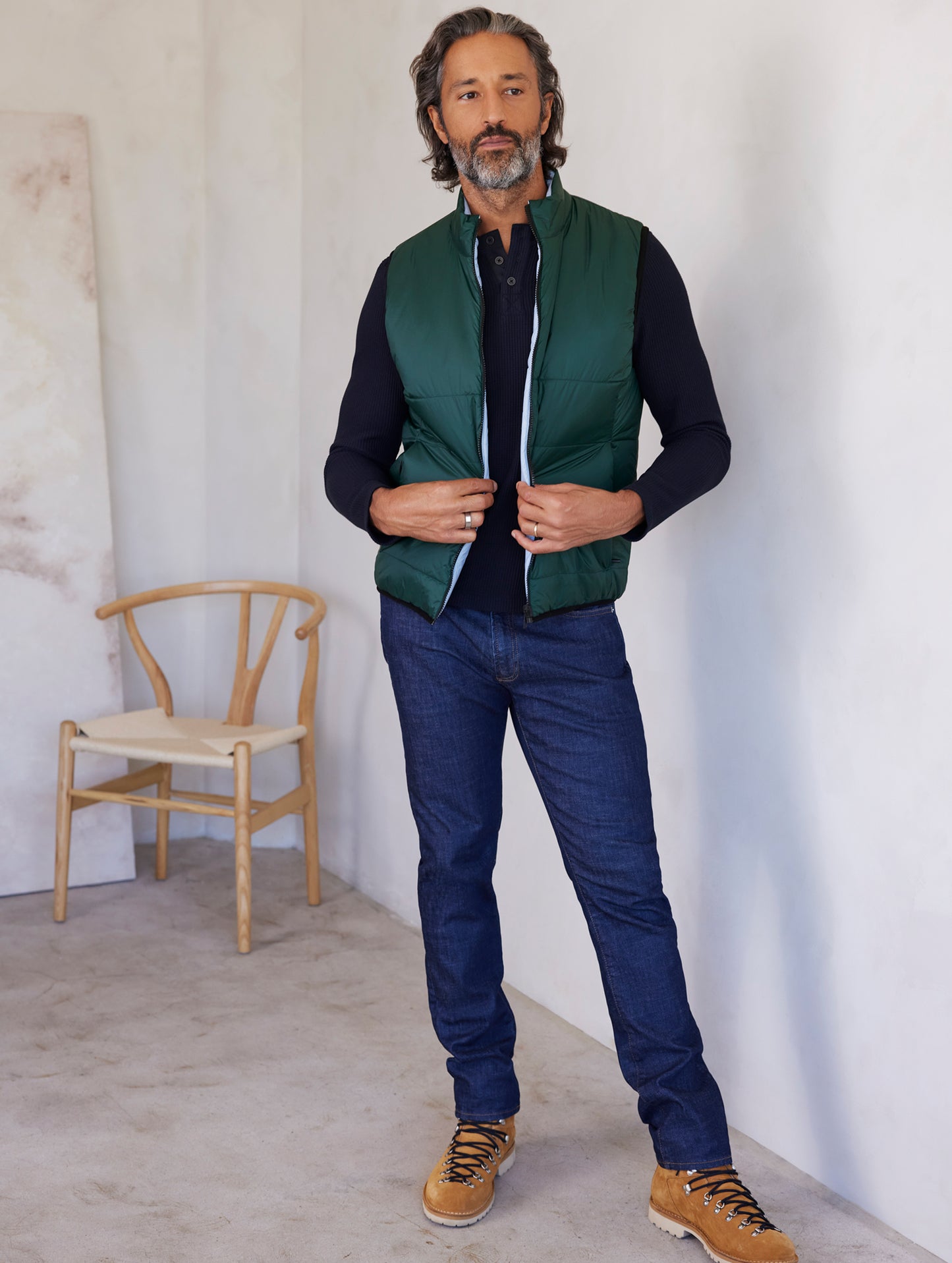 man wearing green side of reversible insulated vest