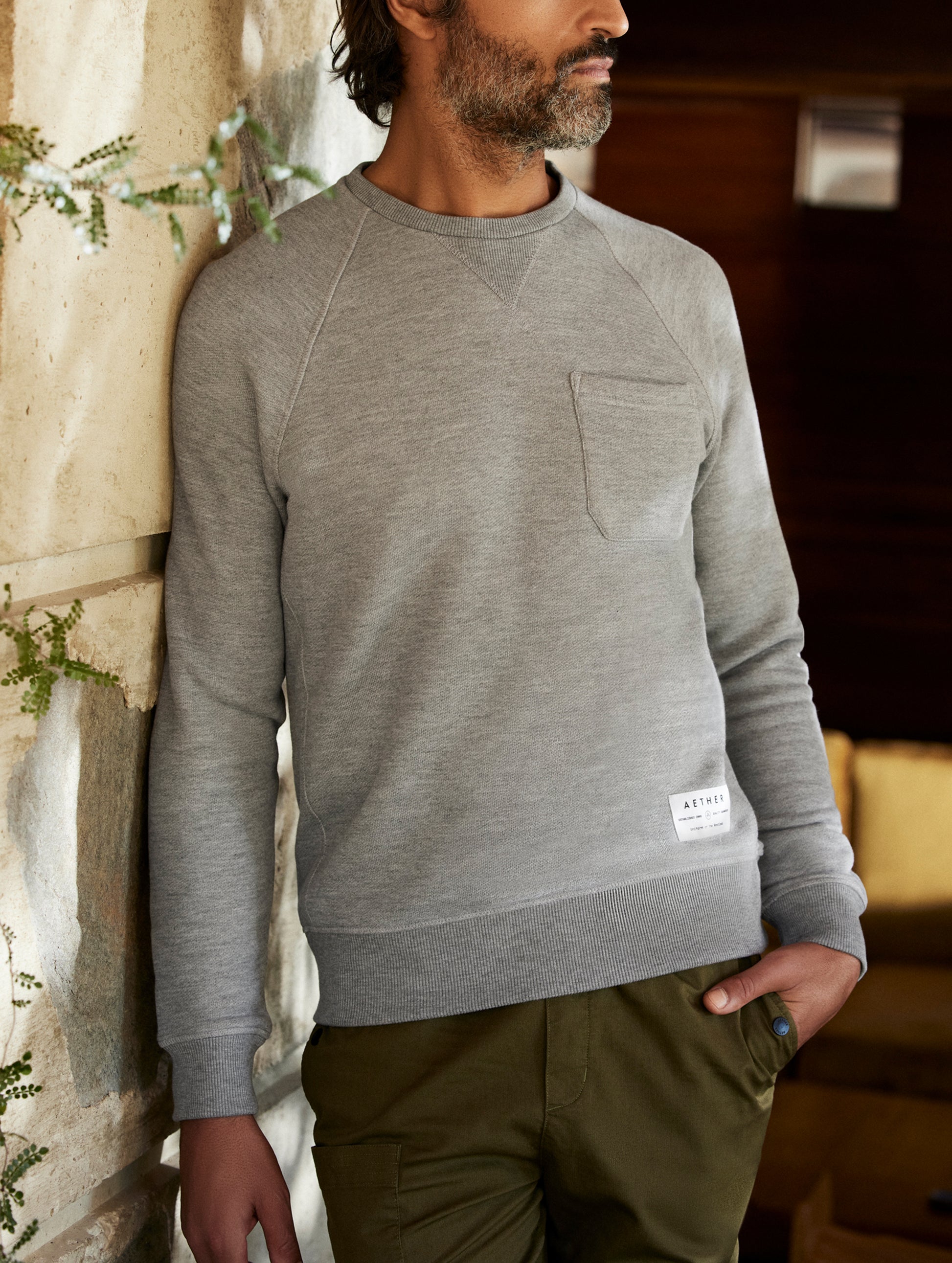 man wearing a grey crew neck with pocket