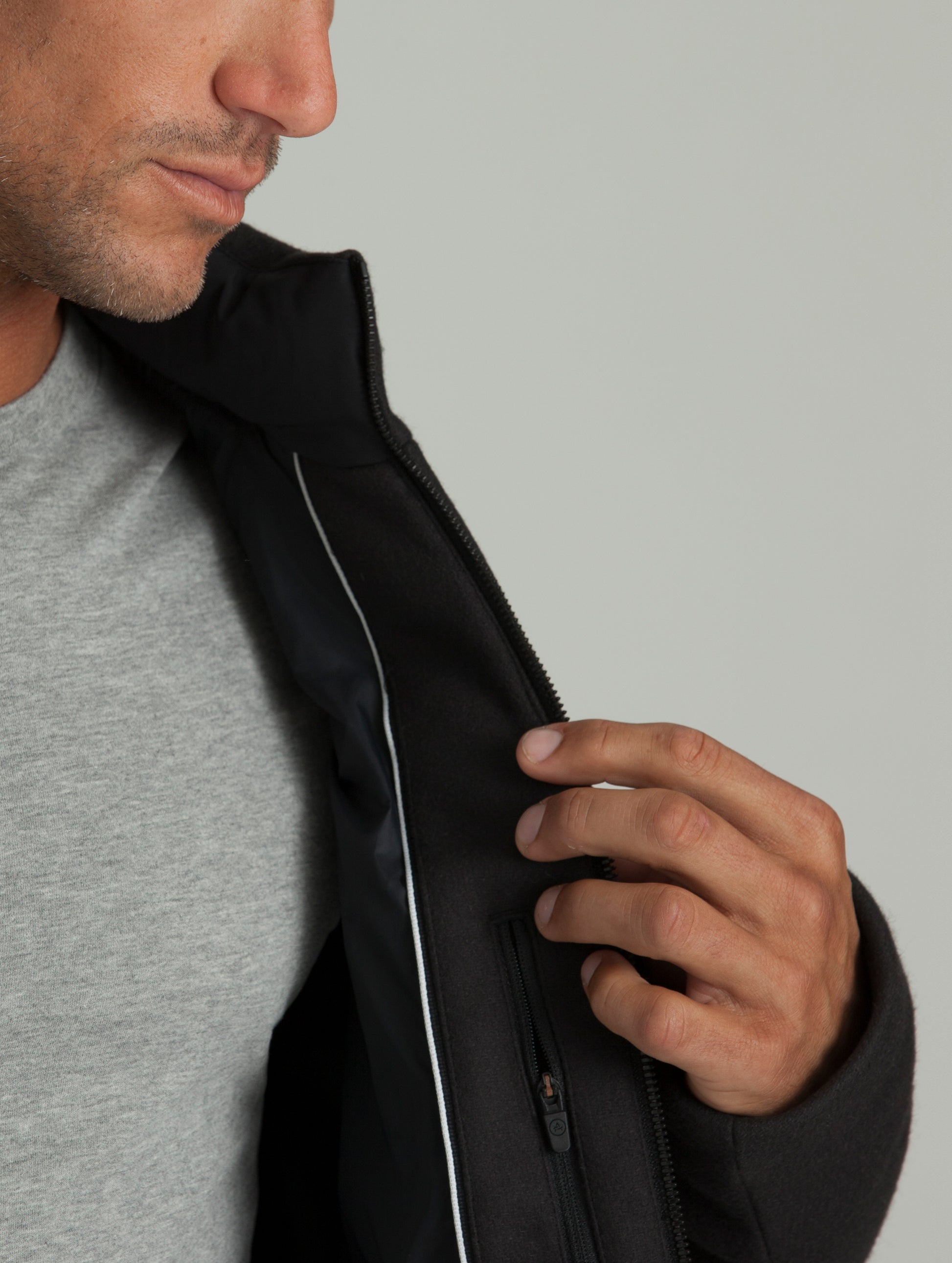 Man wearing black Hopkins Jacket from AETHER Apparel, displaying interior left pocket.