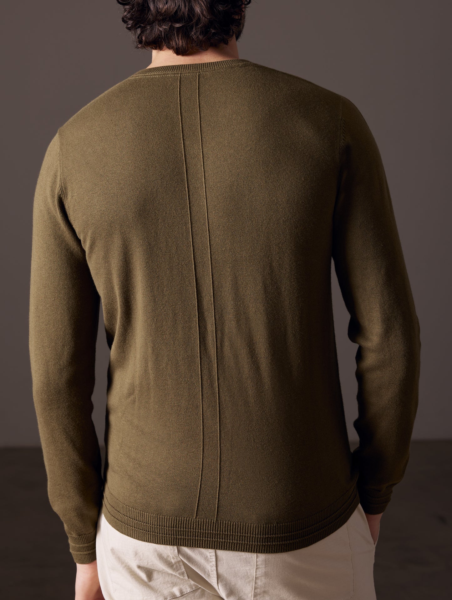 back view of man wearing green sweater