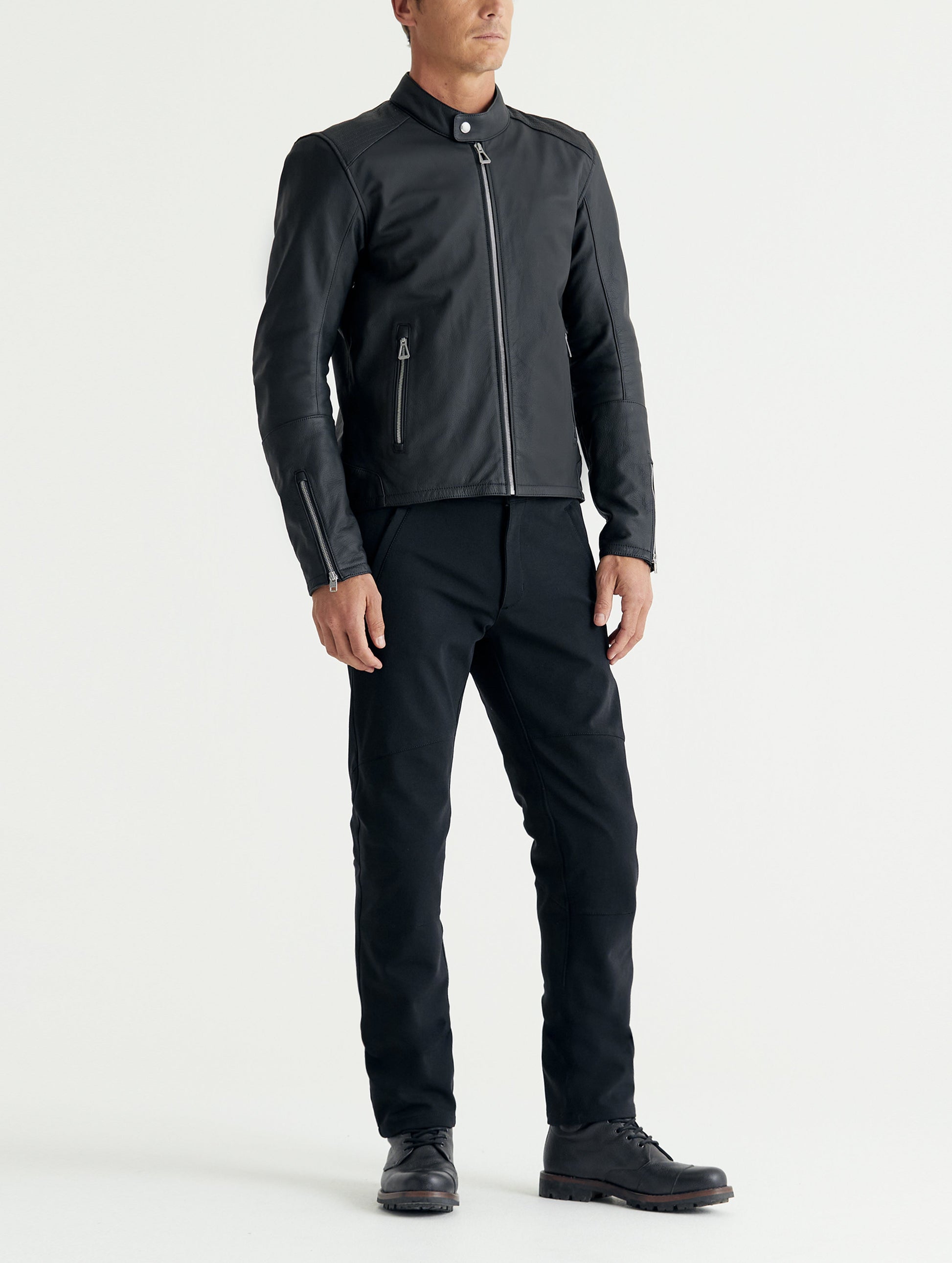 Front 3/4 full-body view of man wearing Laslo Motorcycle Jacket in Onyx Black from AETHER Apparel.
