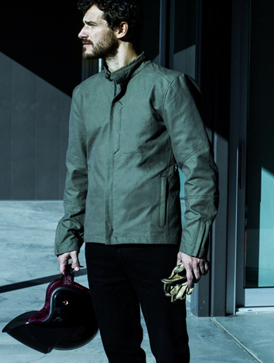 Man outdoors wearing dark grey Loop Motorcycle Jacket from AETHER Apparel.