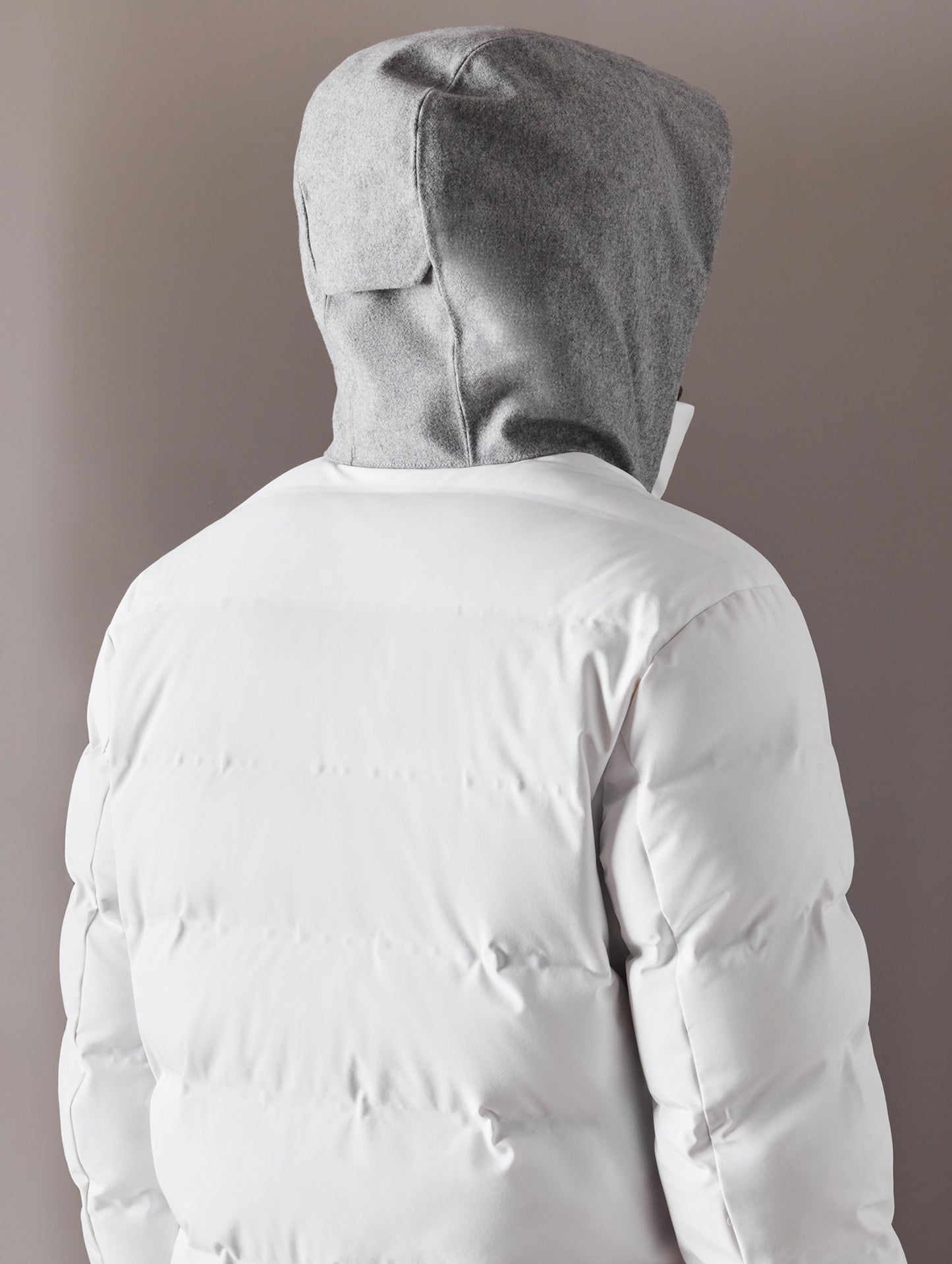 back view of man wearing white ski jacket from AETHER Apparel