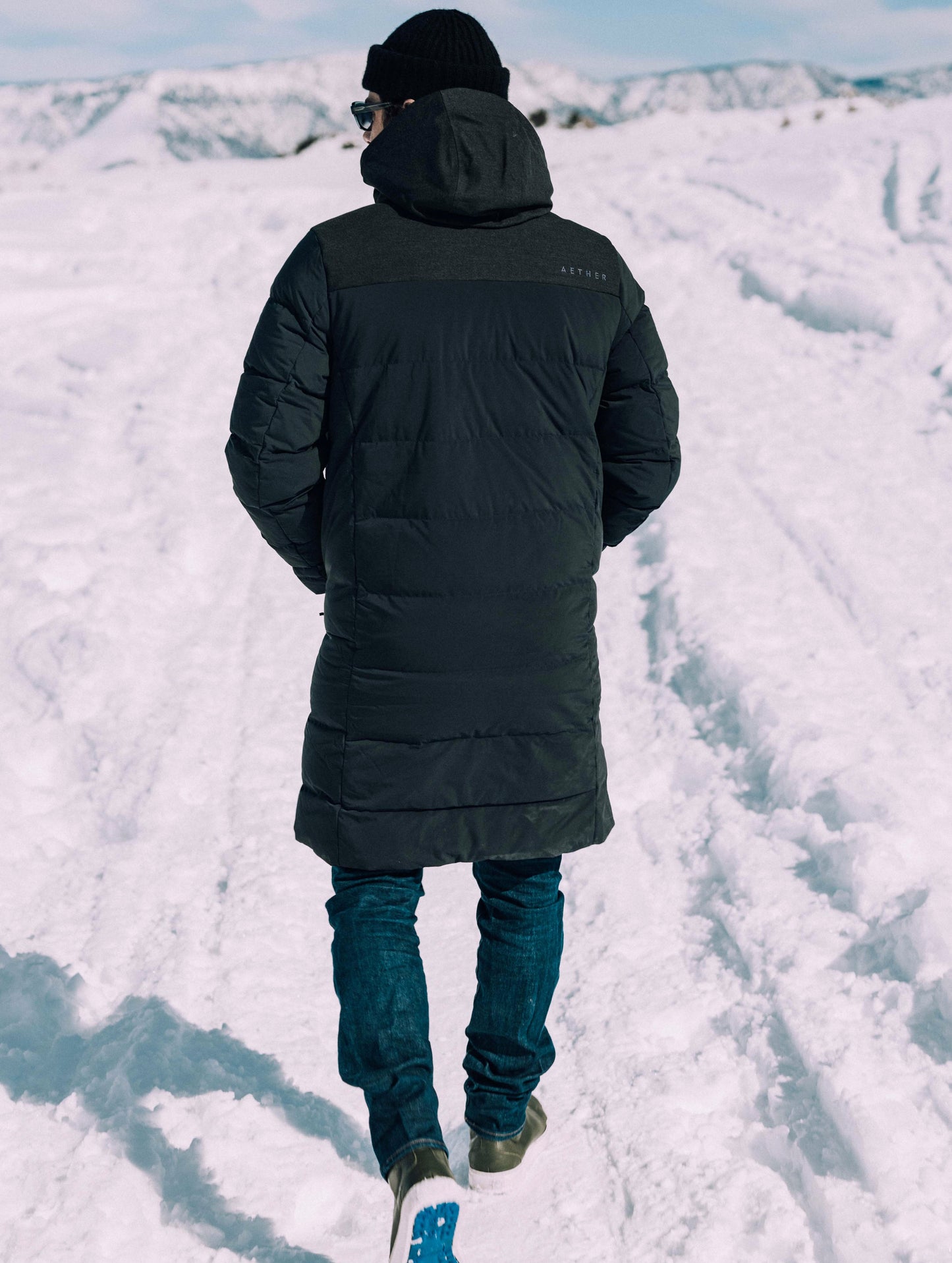 man wearing black parka in snow