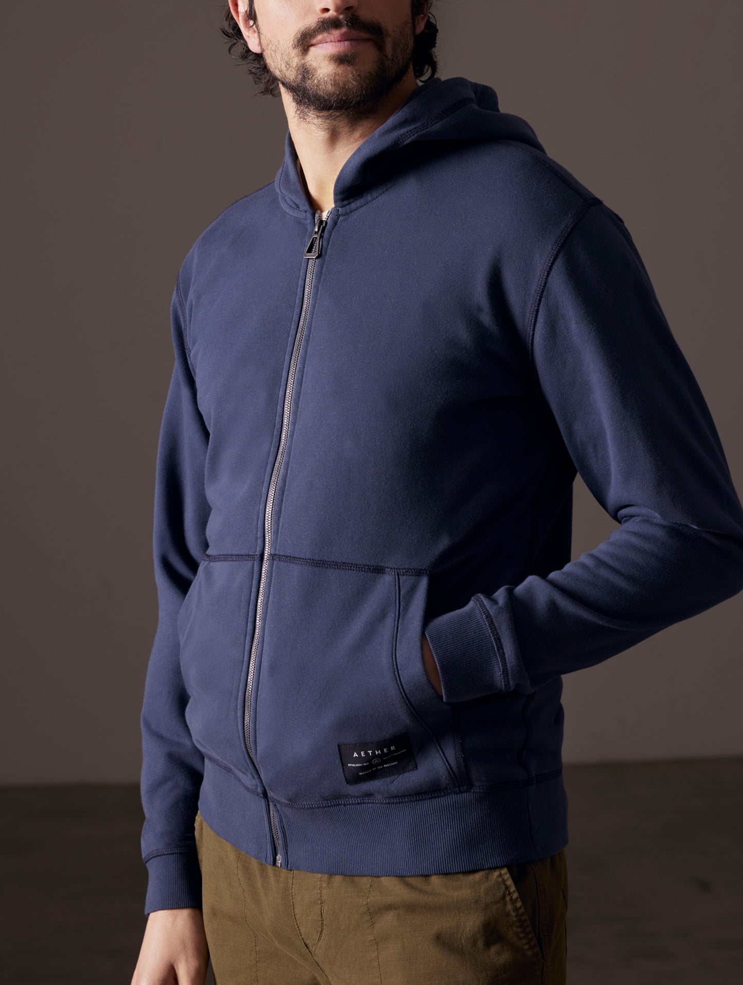 Man wearing blue full-zip hoodie from AETHER Apparel