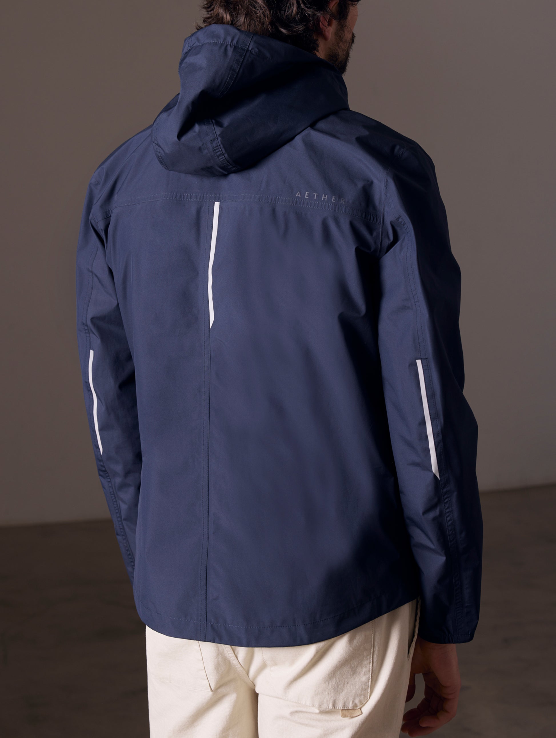 back view of man wearing blue waterproof jacket