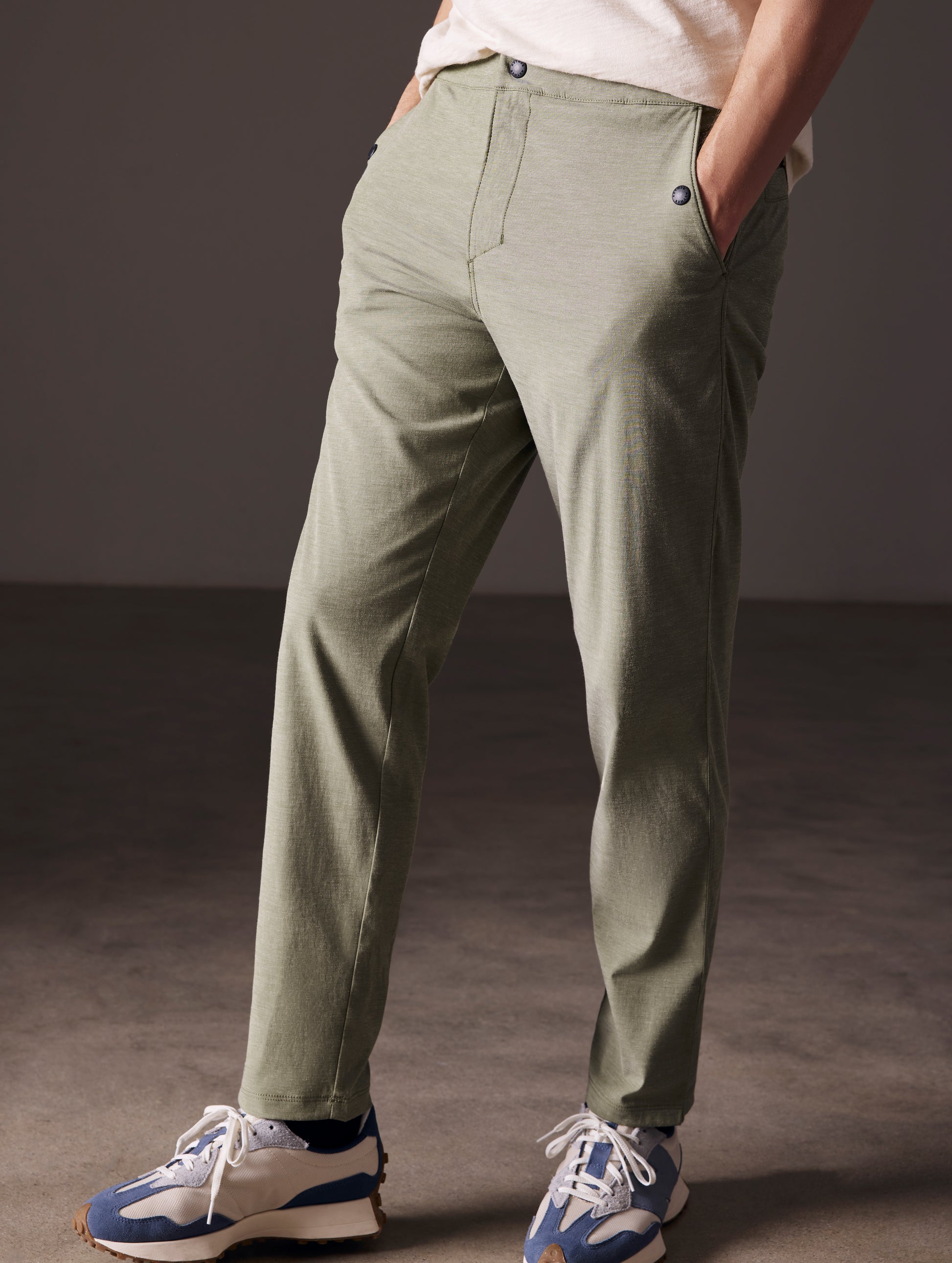 Front angled lower body view of man wearing Strand Tech Pant in Command Green from AETHER Apparel.