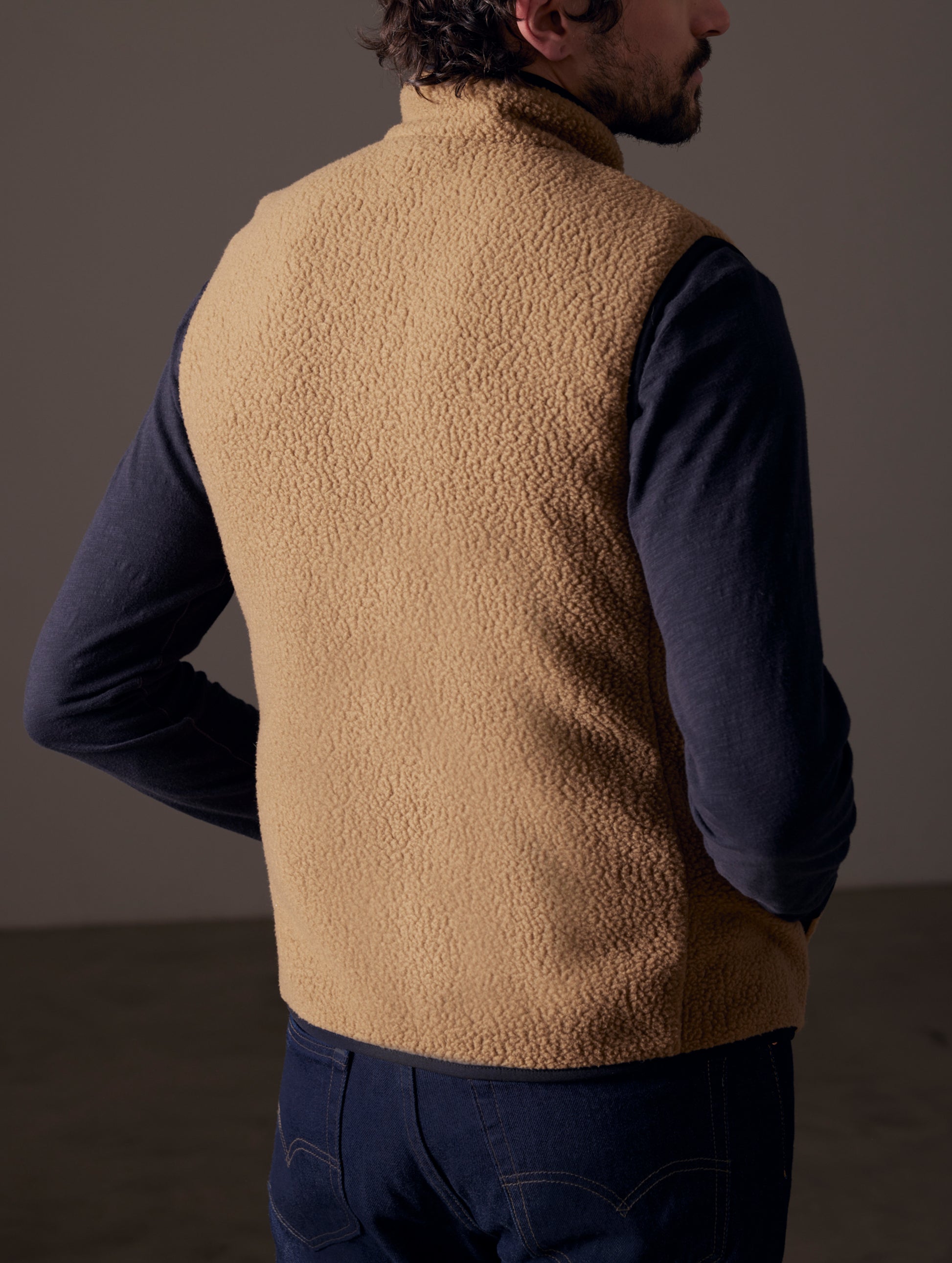 back view of man wearing brown fleece vest