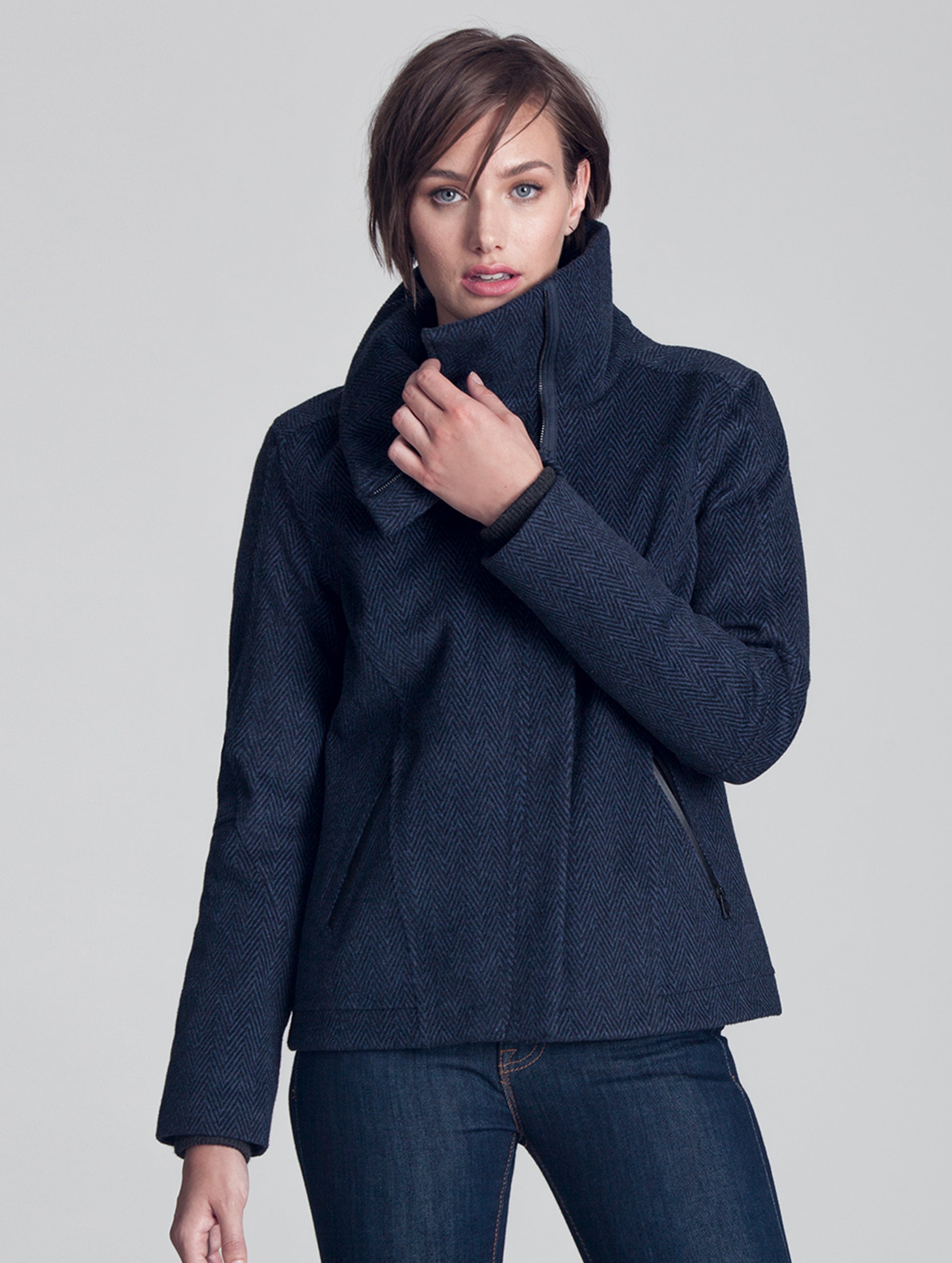 Woman indoors wearing blue Crosby Jacket from AETHER Apparel.