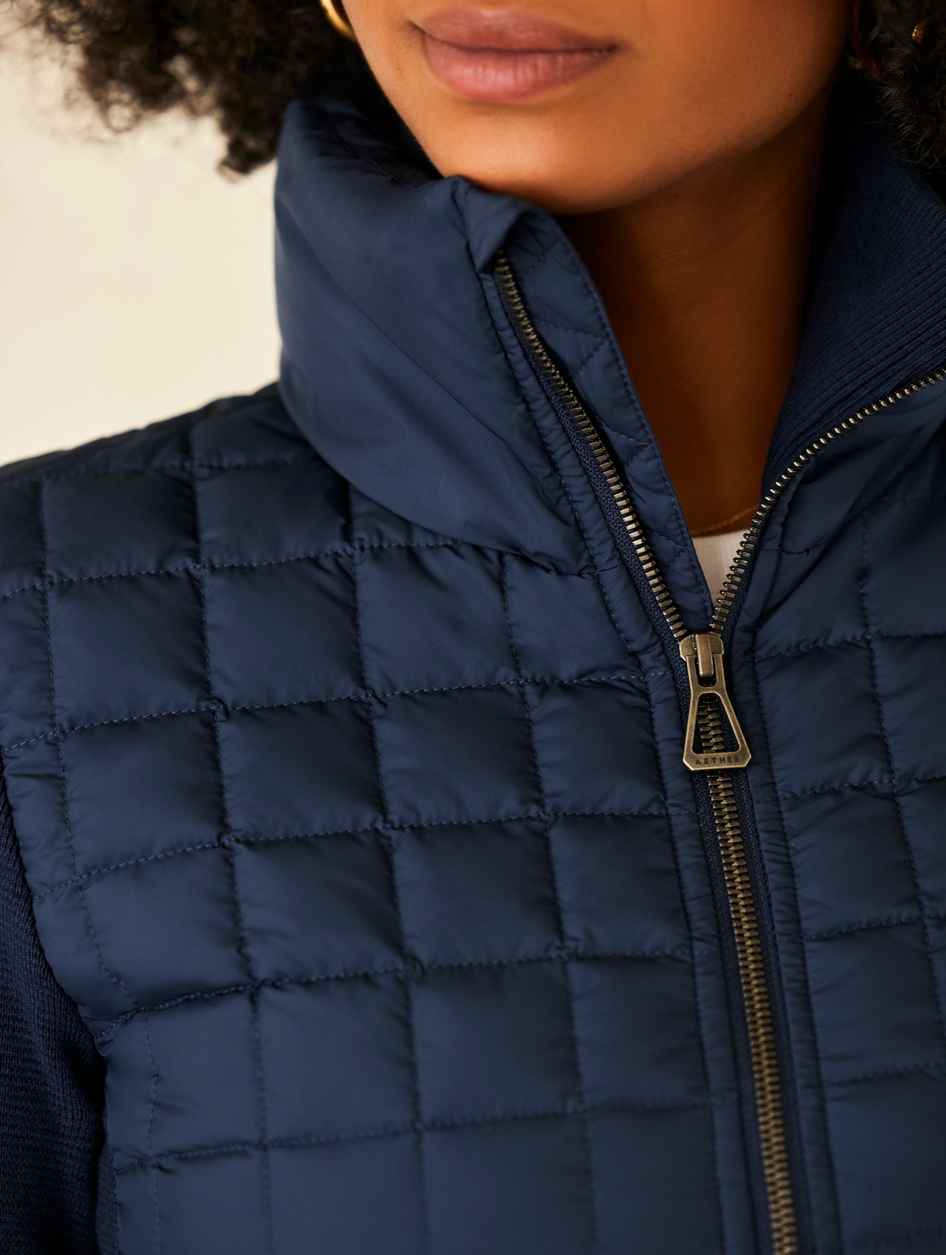 woman wearing quilted blue full-zip sweater
