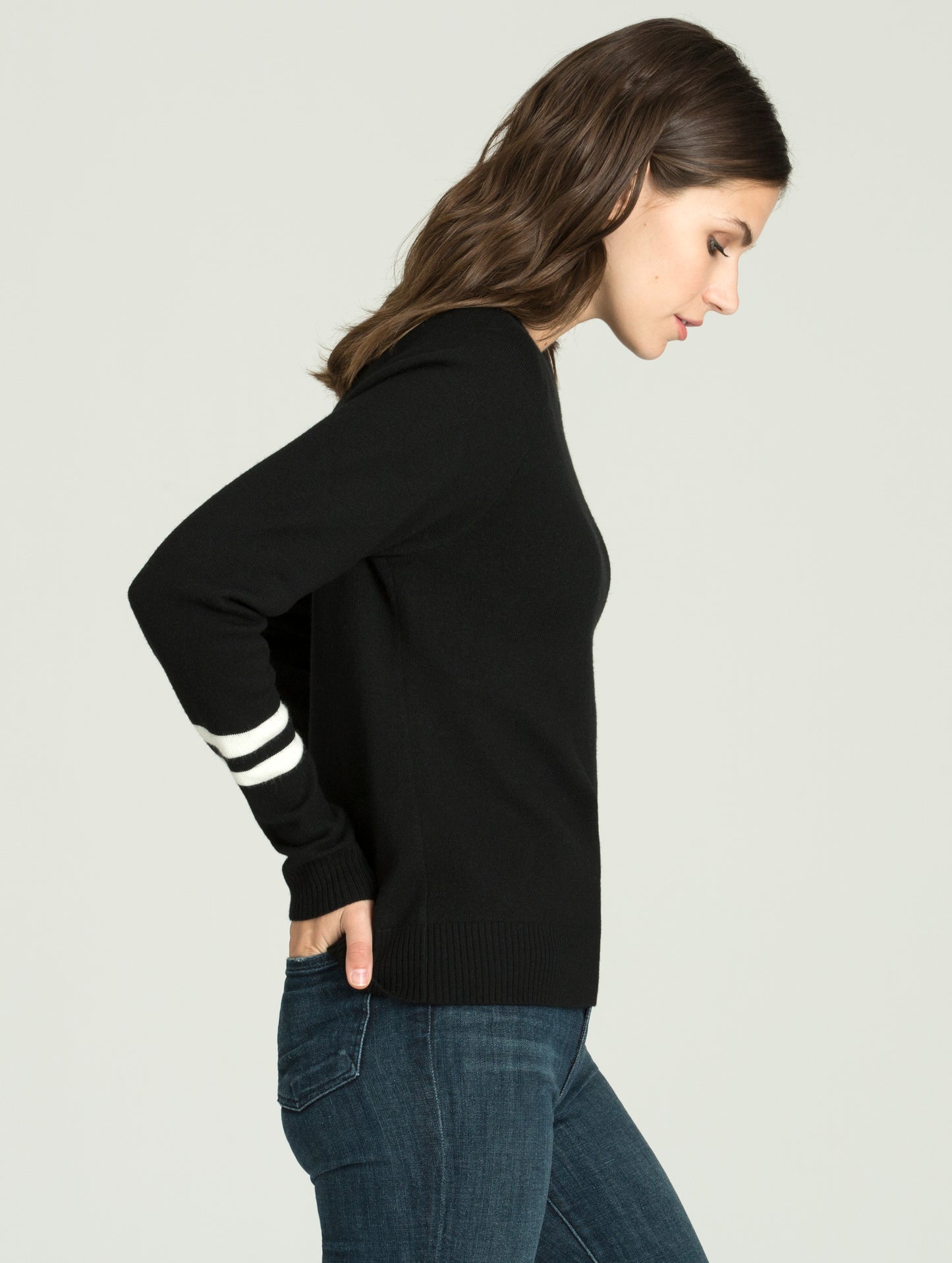 Side profile view of woman wearing Racer Sweater in Onyx Black from AETHER Apparel.