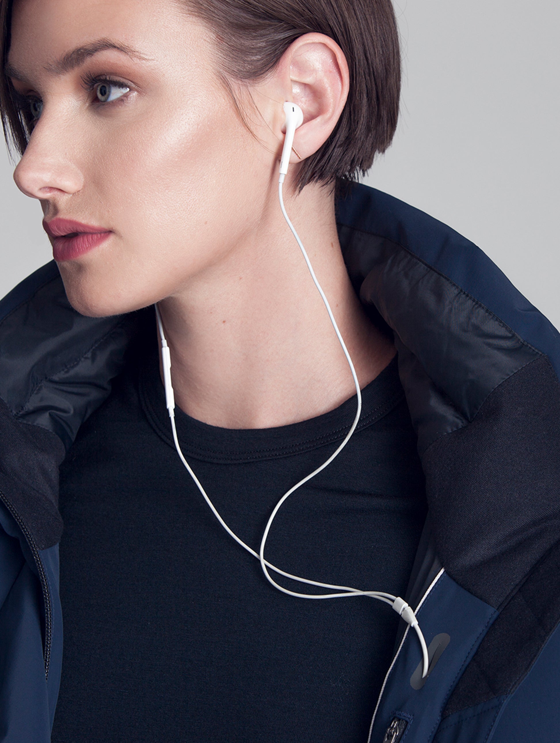 Close collar-focused view of woman wearing blue Vertical Jacket from AETHER Apparel.